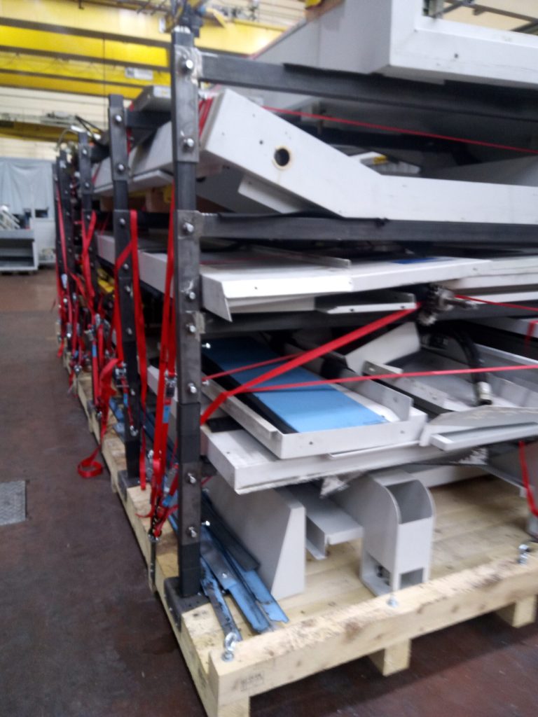 Transportpalette mit gesicherten demontierten Maschinenbauteilen in einem mehrstöckigen Stahlrahmen